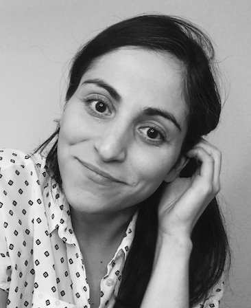Black and white headshot of Sarah Naftalis in a patterned blouse, leaning her head to the right.