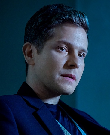 Matt Czuchry headshot wearing a navy suit sitting against a gray background for AHS: Delicate