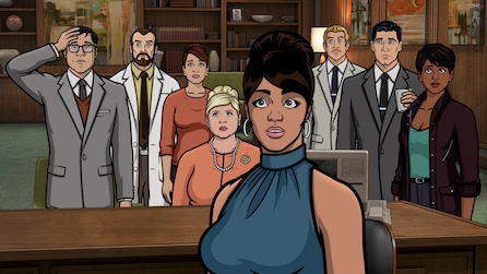 Lana wearing a blue top while several others stand behind her in an office.