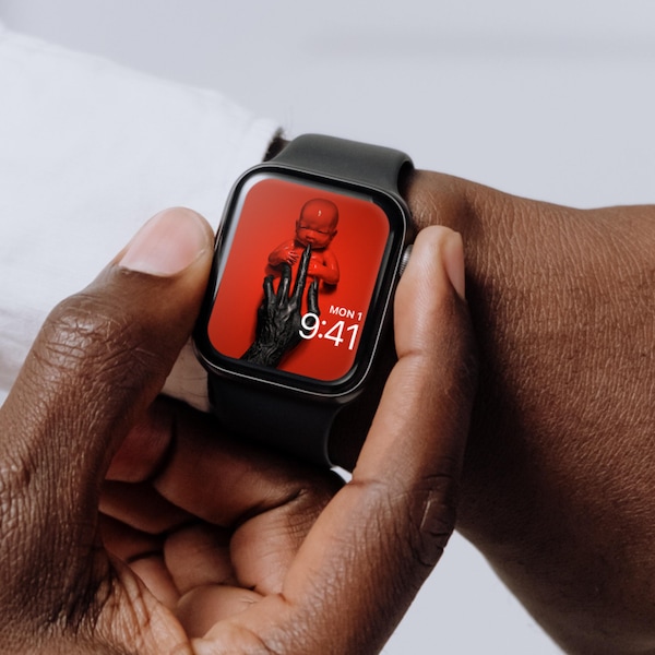 Man wearing Apple Watch with lock screen of red baby with black claws held by black hands American Horror Story 8 Apocalypse
