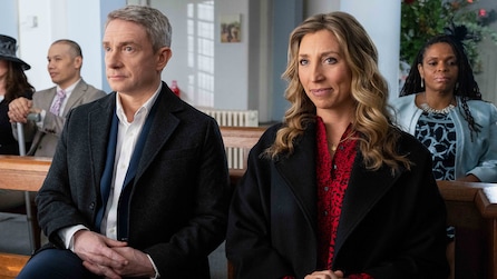 Ally and Paul sitting next to each other on a bench inside 