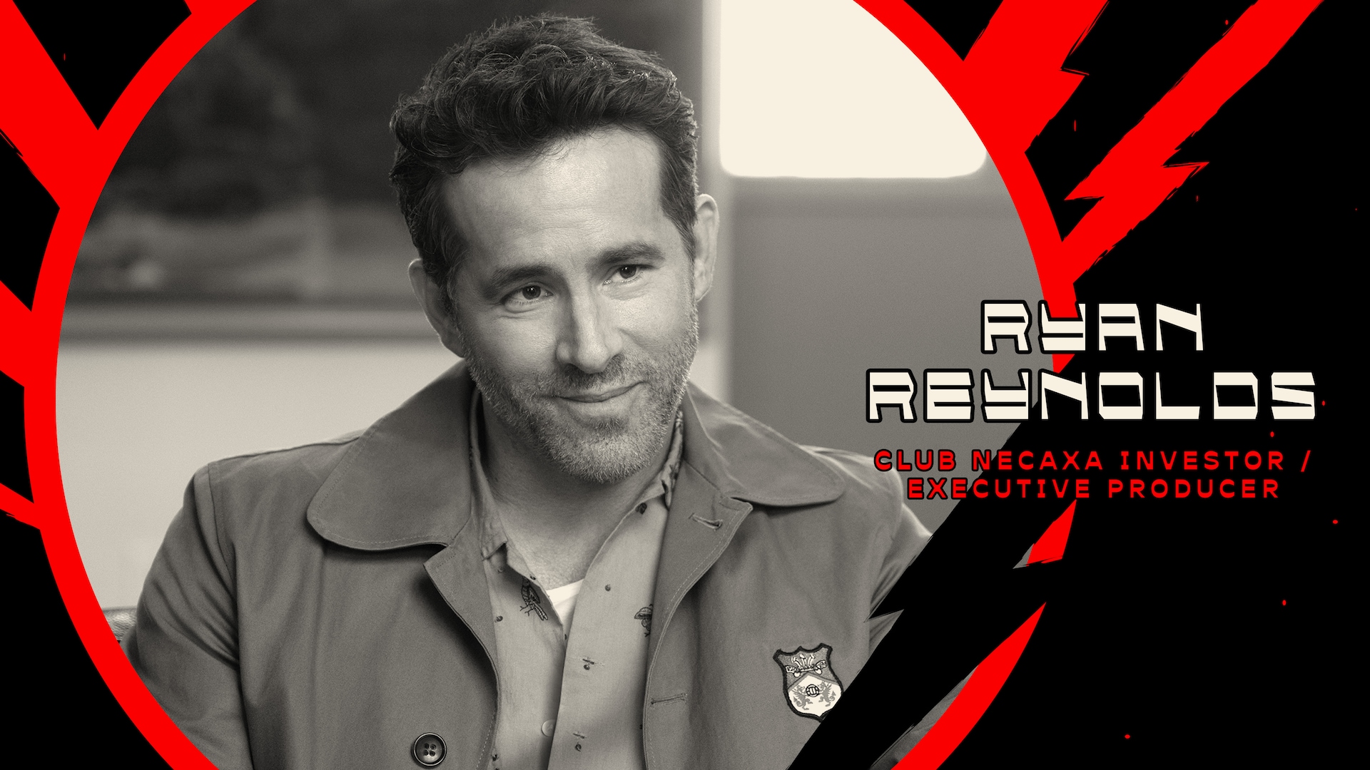 Ryan Reynolds wearing a coat over a button up with a black and red electric background circled around him.
