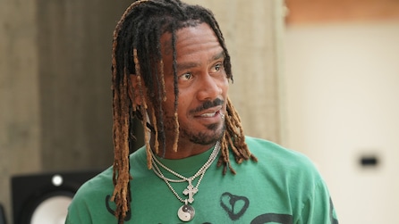 GaTa wearing a green shirt with a black heart on it and chain necklaces