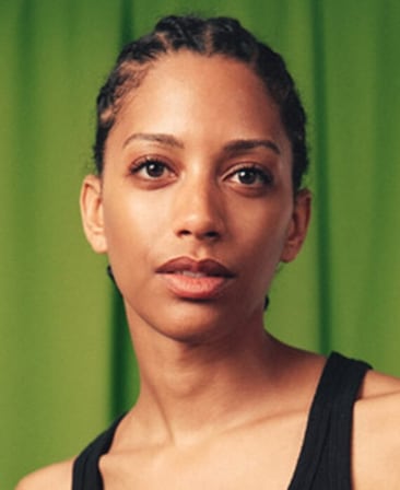 Headshot of executive producer Stefani Robinson wearing a black tank top, with a bright green background behind her.