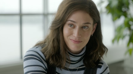 Lizzy Caplan as Libby Epstein smiling in black and white turtleneck in sunny room in FX's Fleishman Is In Trouble