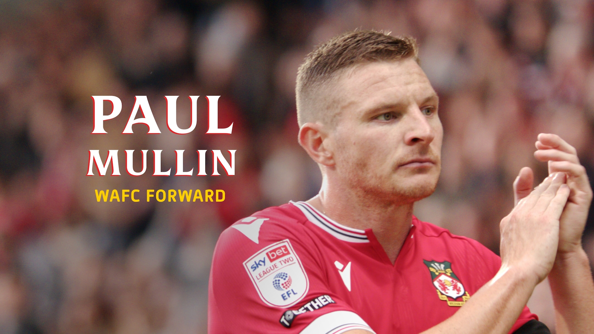 Paul Mullin headshot wearing a red shirt with a striped collar