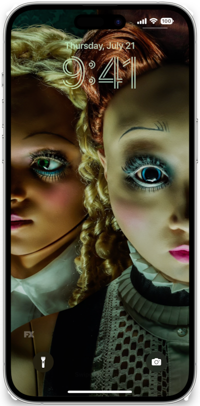 iPhone lock screen of dolls with wide eyes and colorful garments and makeup from FX's American Horror Stories