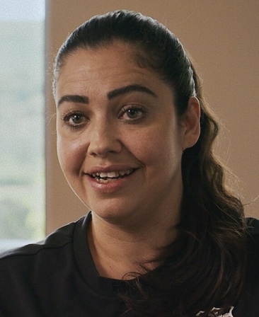 Gemma Owen headshot wearing a black zip up sitting in front of a window