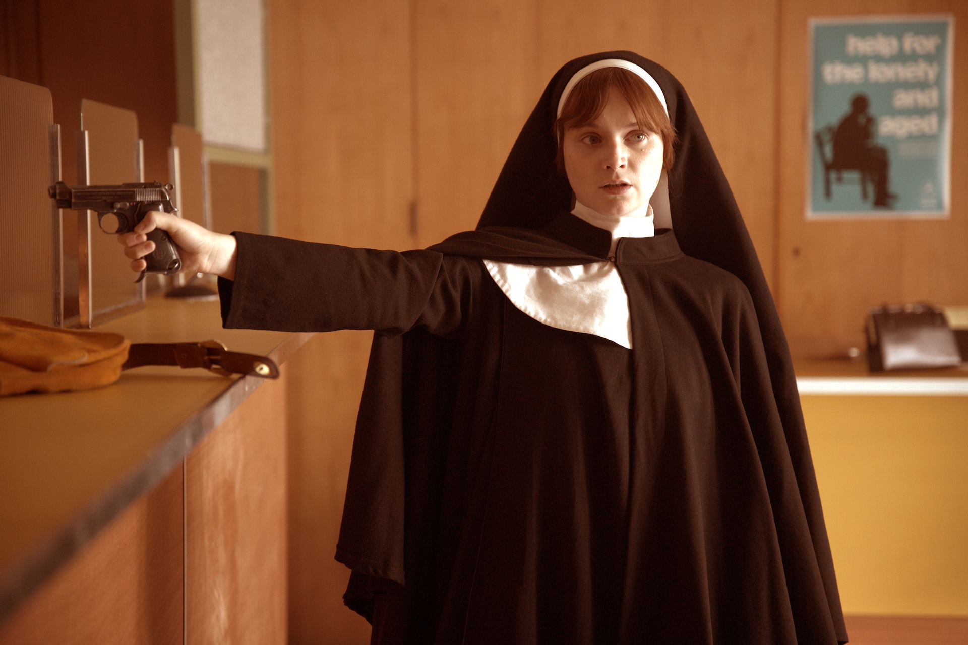 Lola Petticrew as Dolours Price in FX's Say Nothing wearing a a habit holding a weapon.