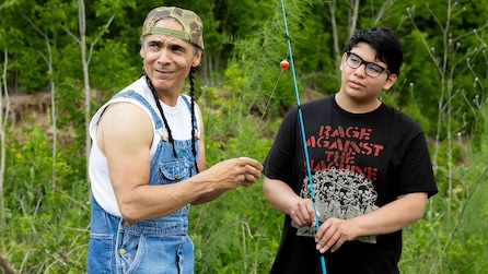 Cheese and Spirit standing outside in the forrest holding fishing rods