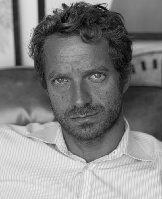 Headshot of Tom Rob Smith in a white striped button down for FX's Class of 09