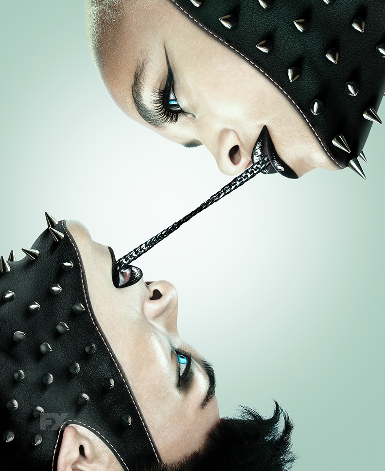 Two people with bright blue eyes connected with black metal chain from their mouths from FX's AHS NYC