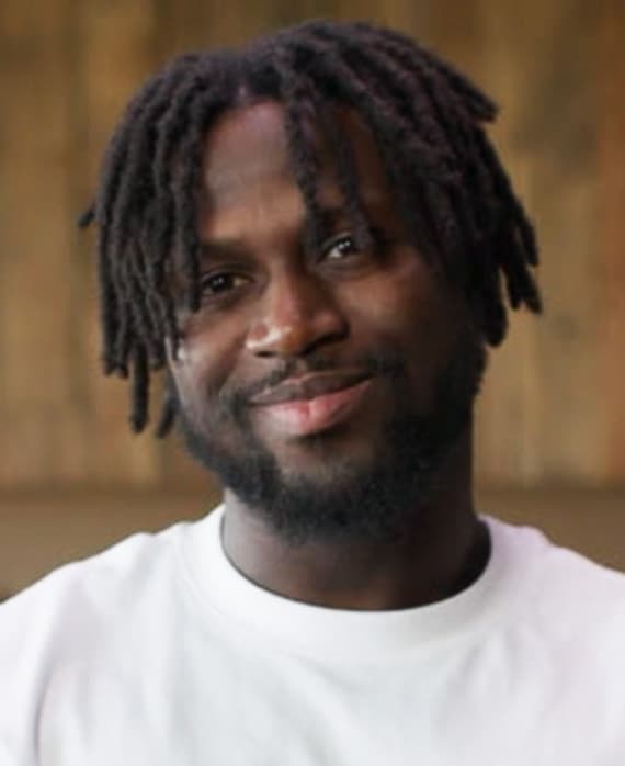 Jacob Mendy headshot wearing a white shirt, standing in front of a neutral background