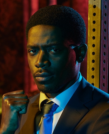 Damson Idris headshot wearing a suit and holding a fist