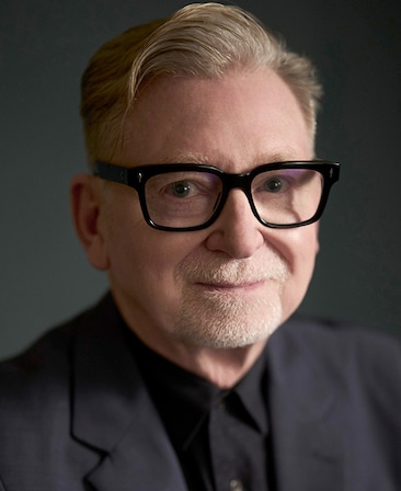 Warren Littlefield headshot wearing a black suit and glasses