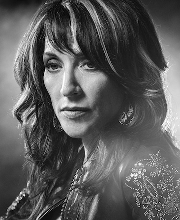 Katey Segal headshot wearing a bedazzled jacket with highlights in her hair