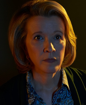 Linda Emond headshot wearing a pattern shirt and sweater