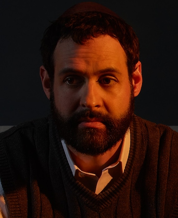 Andrew Leeds headshot wearing a white collar shirt with black sweater