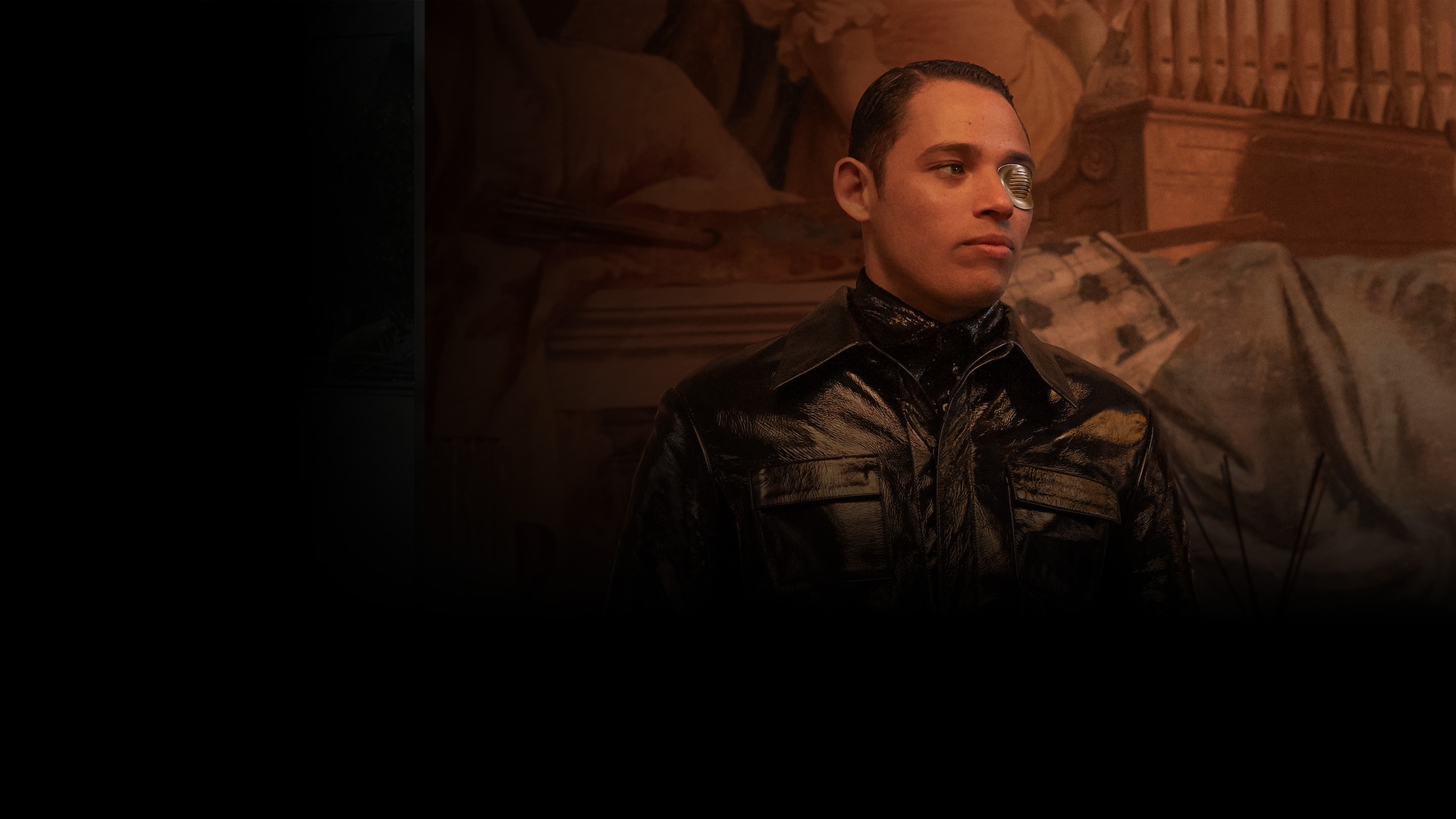 Anthony Ramos wearing an eye patch and an all black suit.