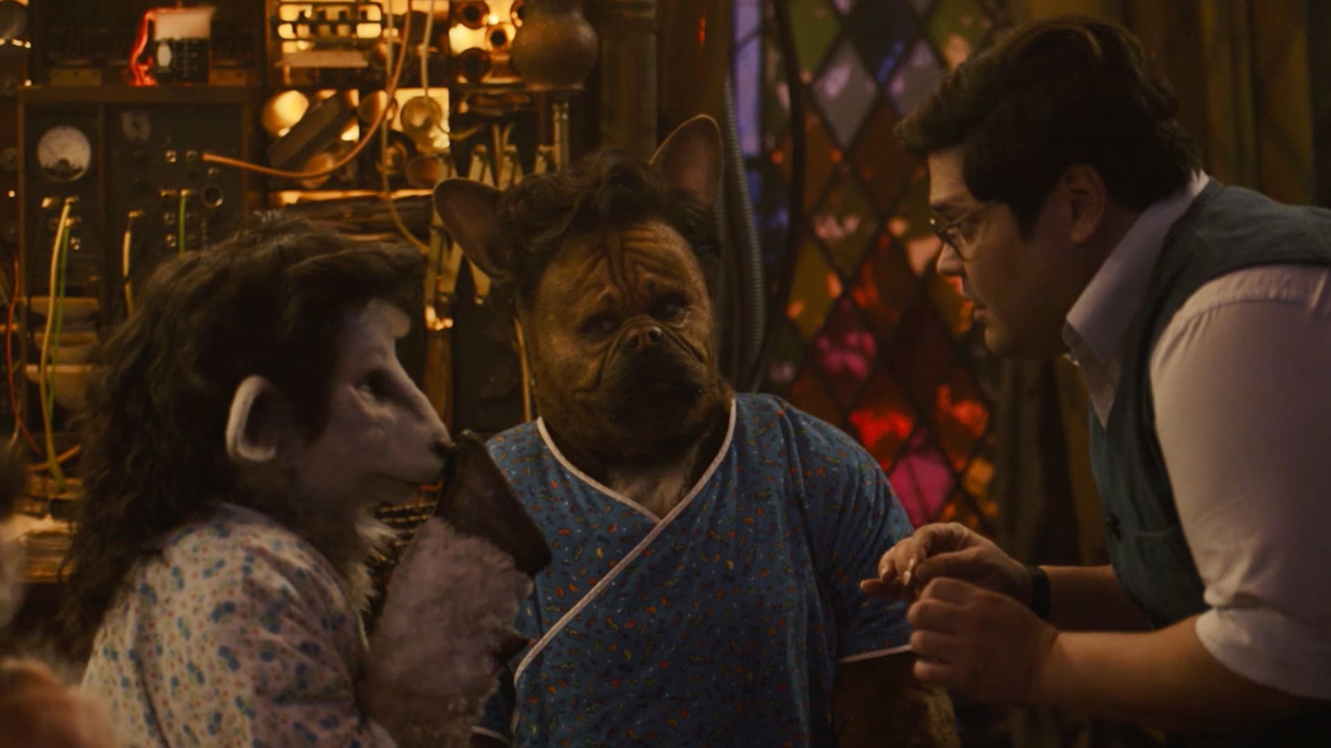 Guillermo leaning down talking with his animal like clones in Laszlo's laboratory.