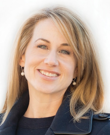 Lisa Blum headshot in black shirt and black coat with plain white background
