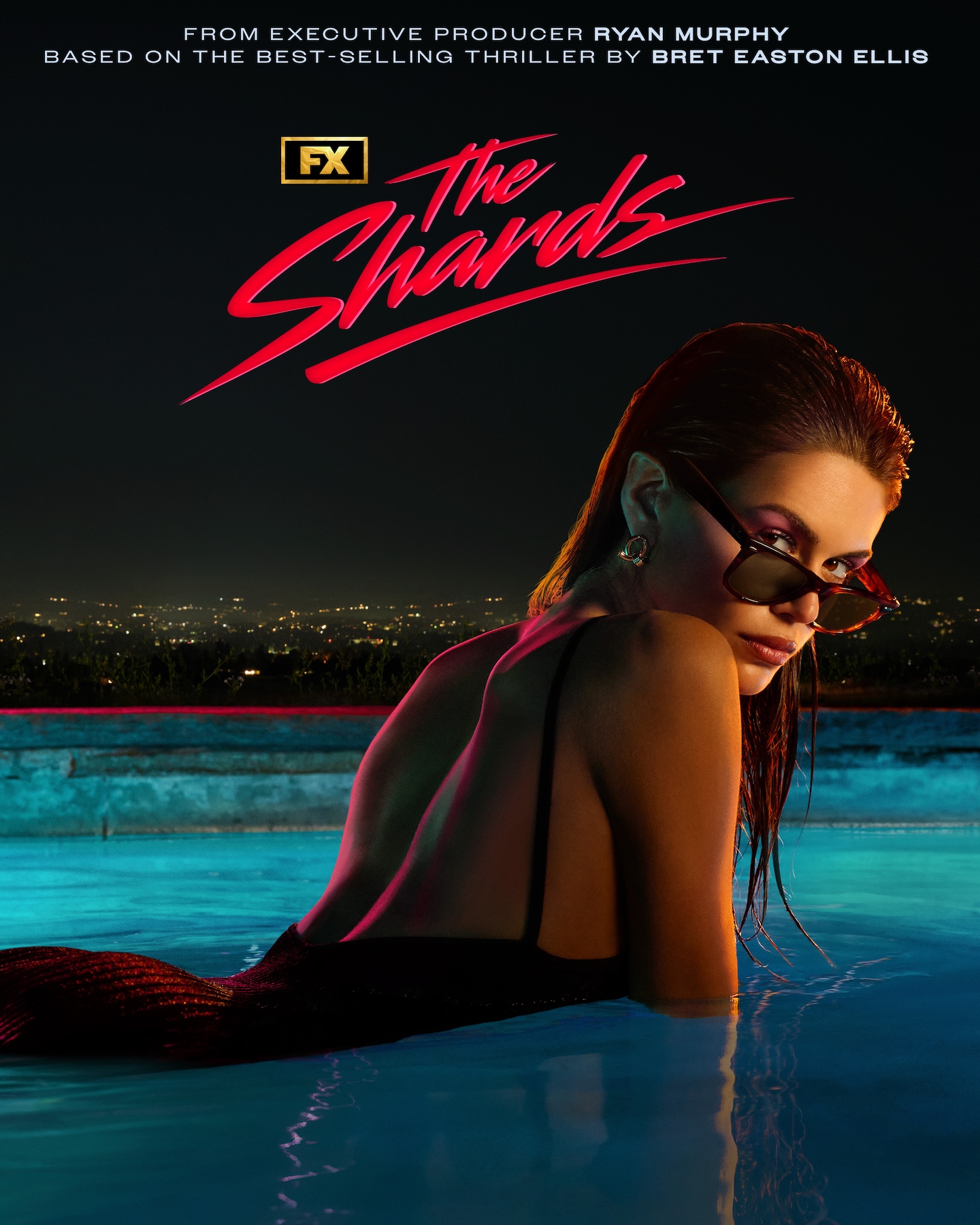 FX's The Shards Kaia Gerber halfway in a swimming pool wearing a black swimsuit and sunglasses at night.