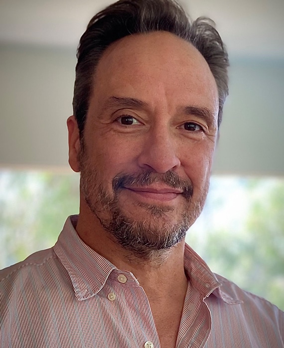 Headshot of executive producer D.V. DeVincentis in FX's Love Story in a pink button up.
