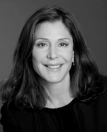 Lauren Shuler black and white headshot in black top with plain grey background