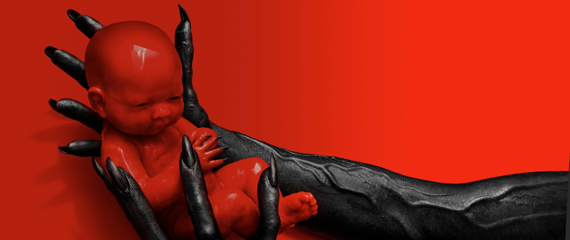 Full body of red doll like baby with black nails held by veiny black arms and hands with long black nails for AHS: Apocalypse
