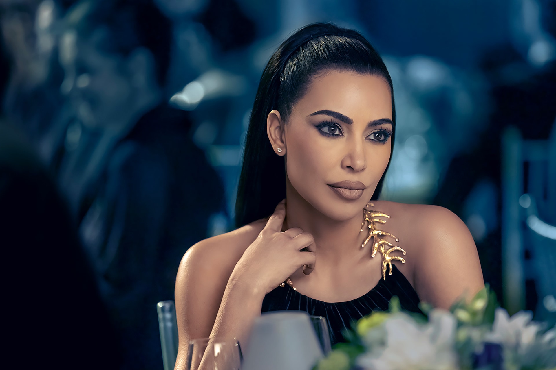 Woman wearing a black top with gold metal detailing for AHS: Delicate