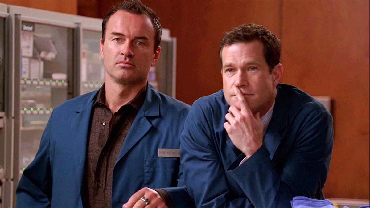 Christian Troy and Sean McNamara wearing blue jackets and leaning over a counter
