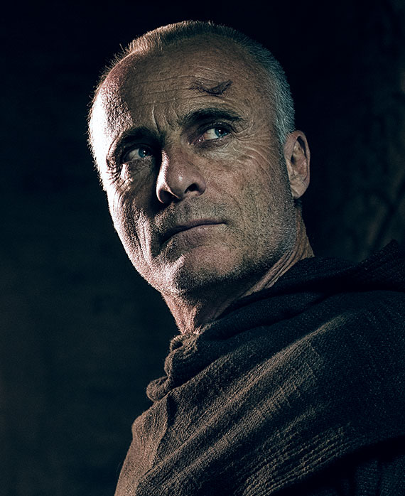 Timothy V. Murphy headshot in layered black robe cloaked over shoulder with scar wound over his left forehead