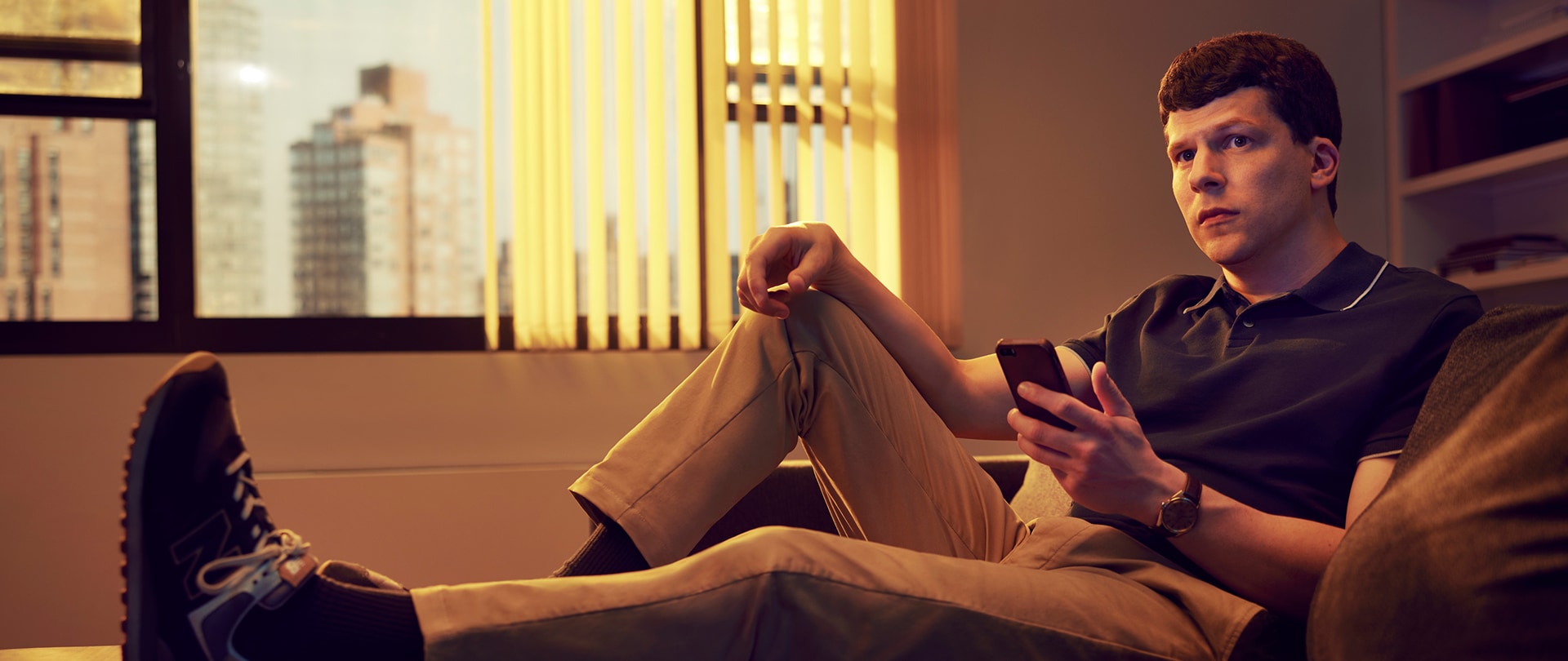 Jesse Eisenberg as Toby Fleishman for FX's Fleishman Is In Trouble laying on a couch.