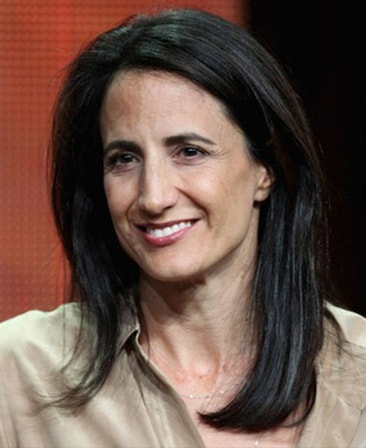 Francie Calfo headshot in light brown top with orange and black background