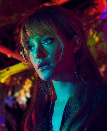 Rachel Keller as Syd in FX's Legion, in a black zip jacket, with teal light shining on face