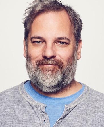 Dan Harmon headshot wearing a blue shirt with a gray shirt over