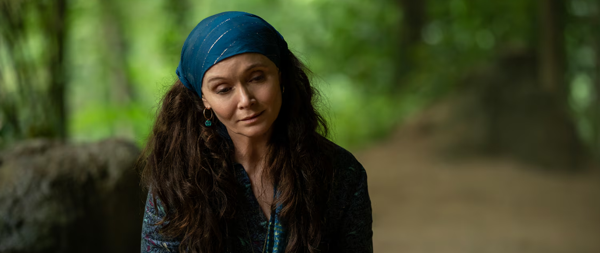 Dame Sylvia sitting outside wearing a blue head scarf