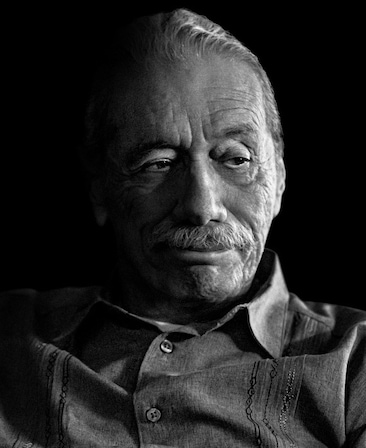 Edward James Olmos headshot fading into the background and wearing a collared shirt with buttons