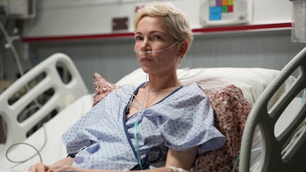 Molly sitting in a hospital bed with an oxygen mask on.