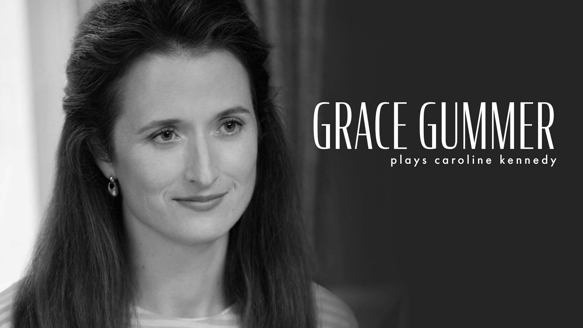 Headshot of Grace Gummer as Caroline Kennedy in FX's Love Story wearing hanging earrings and a striped shirt.