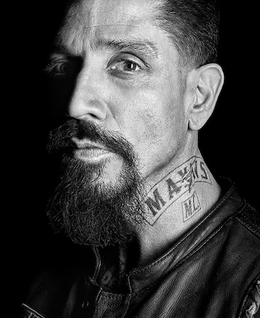 Joseph Lucero headshot with a Mayans M.C. tattoo on the side of his neck