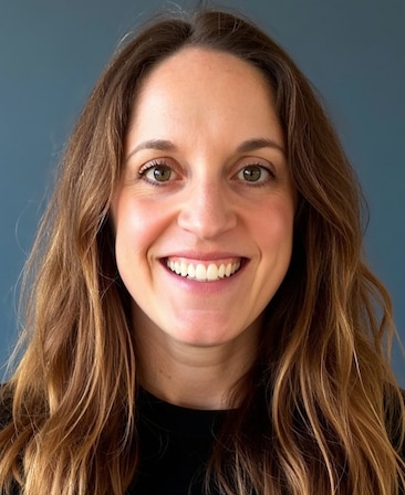 Headshot of executive producer Alicia Van Couvering, wearing a black tshirt with shoulder length brown golden hair.