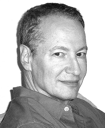 Black and white headshot of Stephen Schiff in dark colored button down looking over his right shoulder against white backdrop