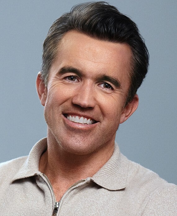 Rob McElhenney headshot wearing a beige zip up sweater