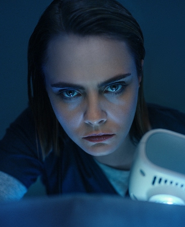 Cara Delevingne headshot wearing scrubs in a dark settings for AHS: Delicate