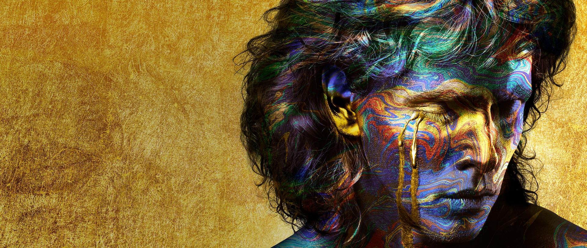 Close up of man's face and long hair covered in swirls of colorful paint with golden tears streaming down face for FX's Trust