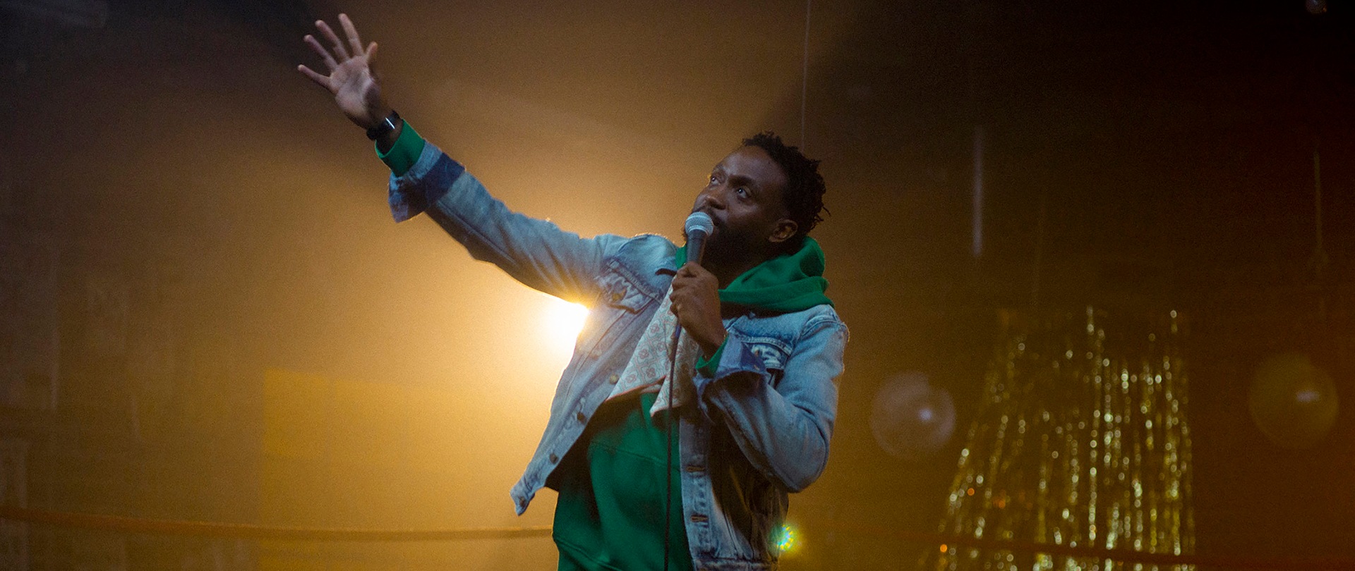 Byron Bowers on stage with a mic
