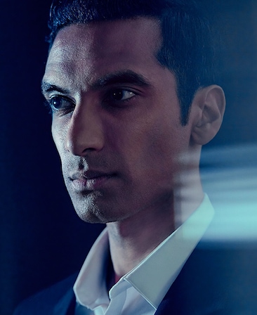 Maaz Ali headshot wearing a white shirt and suit jacket standing in a dark setting for AHS: Delicate