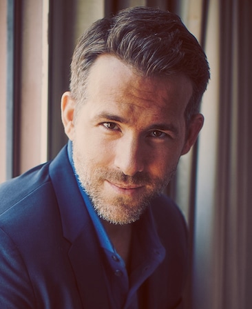Ryan Reynolds Headshot wearing a blue button up and suit jacket