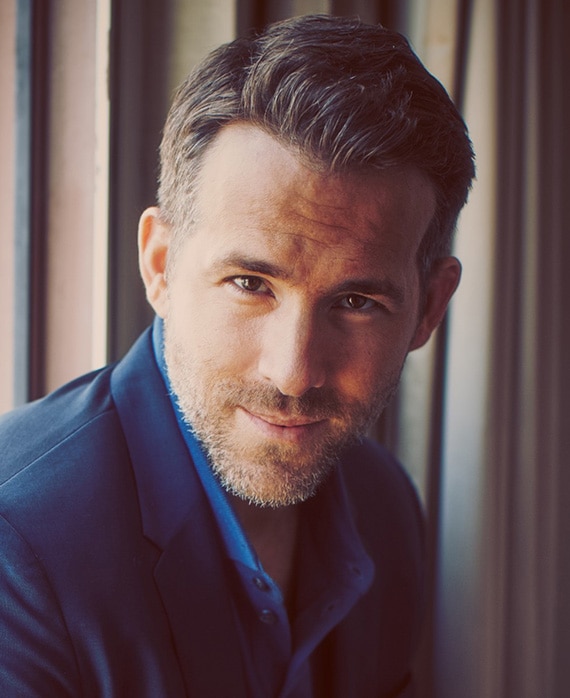 Ryan Reynolds Headshot wearing a blue button up and suit jacket